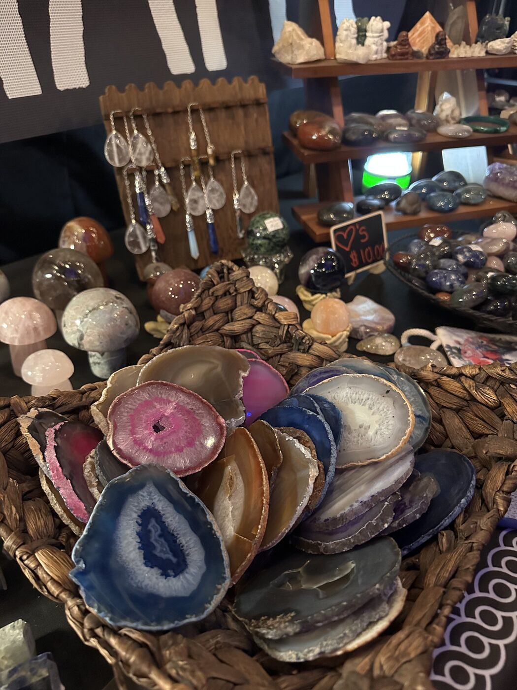 Woven basket filled with pink, blue and banded agate slices at a market table